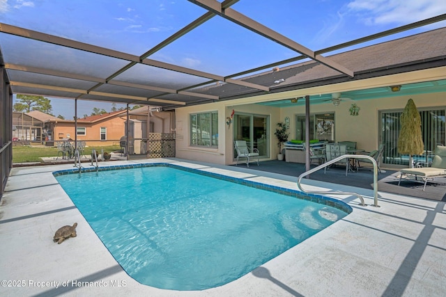 view of pool featuring a patio, ceiling fan, and glass enclosure