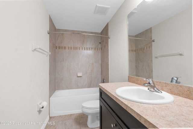 full bathroom featuring tiled shower / bath, vanity, toilet, and tile patterned floors