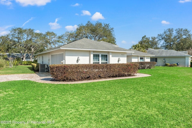 view of property exterior featuring central AC and a lawn