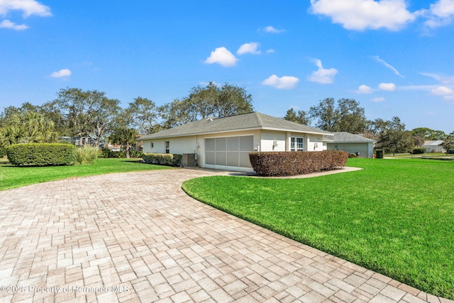 view of side of property featuring a garage and a lawn