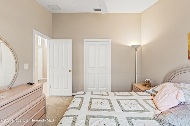 bedroom featuring a closet, visible vents, and light colored carpet