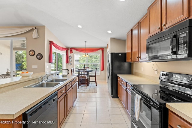 kitchen with decorative light fixtures, light tile patterned floors, light countertops, a sink, and black appliances