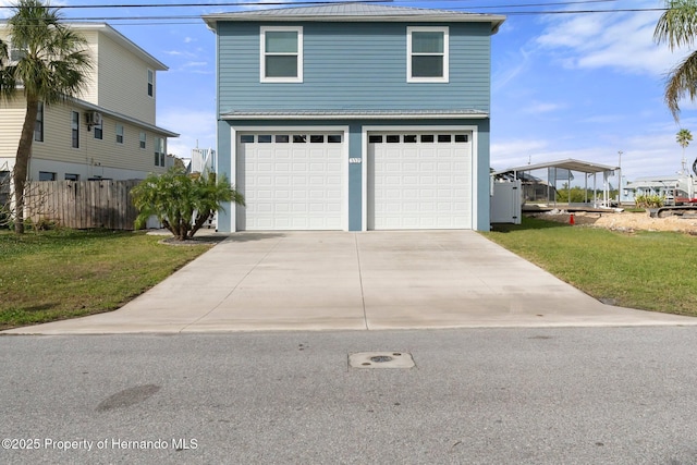 view of front of house featuring an attached garage, metal roof, concrete driveway, and a front yard