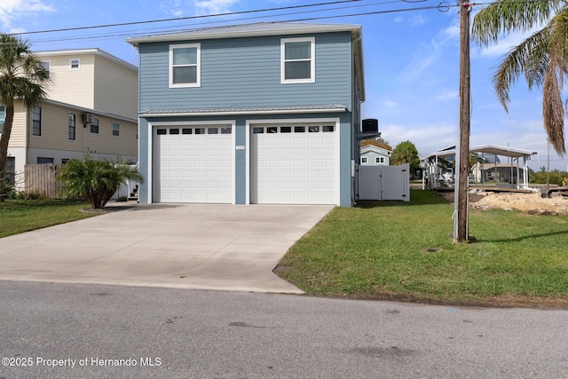 view of front of house featuring concrete driveway, metal roof, a standing seam roof, a gate, and a front yard