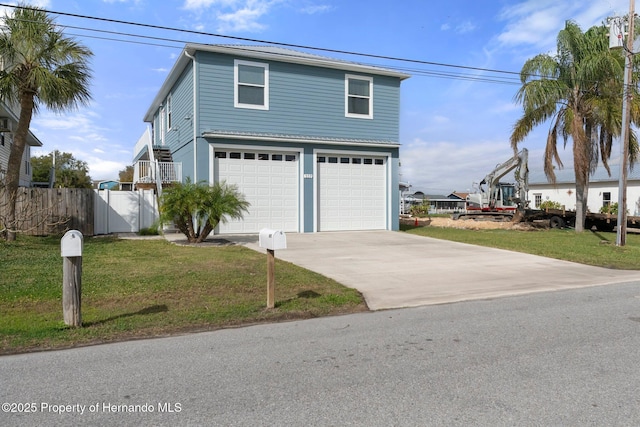 view of front facade with an attached garage, fence, concrete driveway, and a front yard