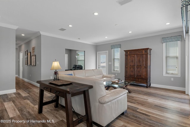 living room featuring light wood-style floors, baseboards, visible vents, and a wealth of natural light