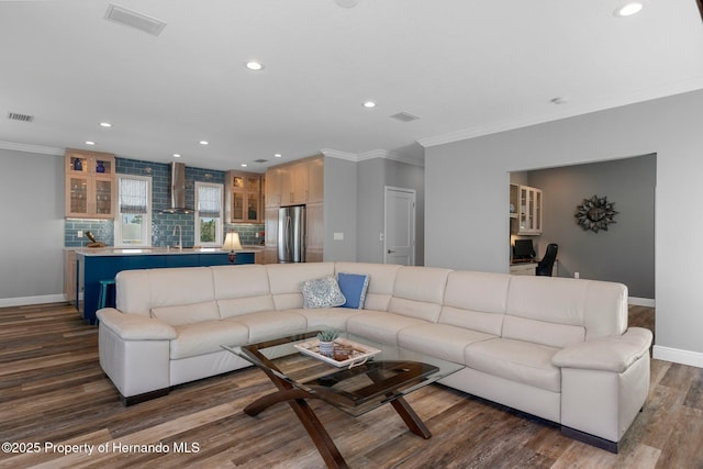 living room featuring dark wood-style floors, ornamental molding, and visible vents