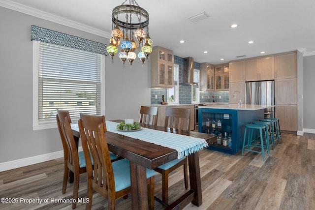 dining area featuring a chandelier, ornamental molding, and baseboards