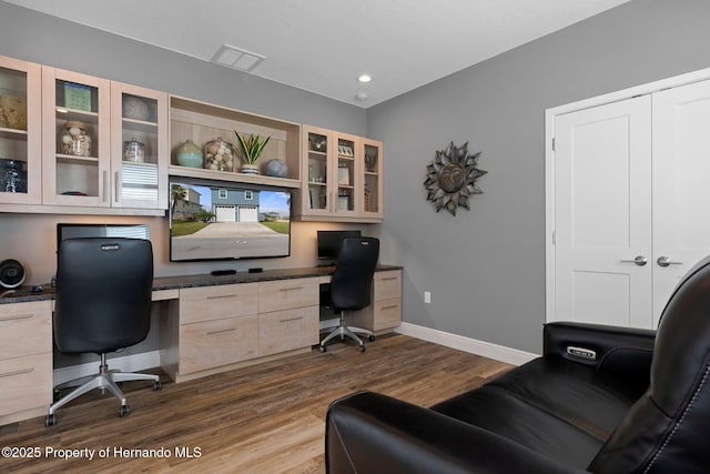 office featuring dark wood-style floors, visible vents, built in desk, and baseboards