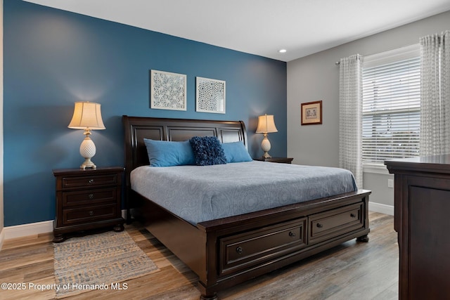 bedroom featuring baseboards and light wood finished floors