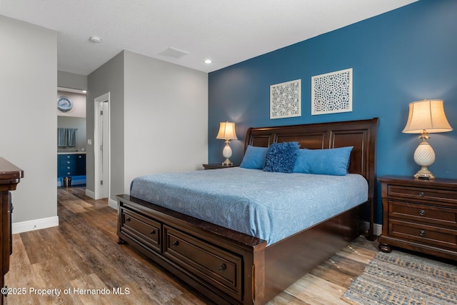 bedroom featuring dark wood finished floors, visible vents, and baseboards