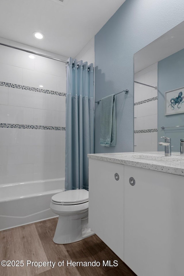 full bathroom with vanity, shower / tub combo, wood finished floors, and toilet