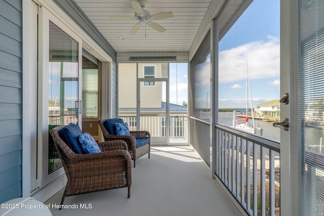 balcony with a water view and a ceiling fan