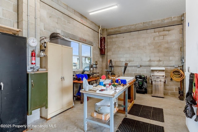 basement with concrete block wall and a workshop area