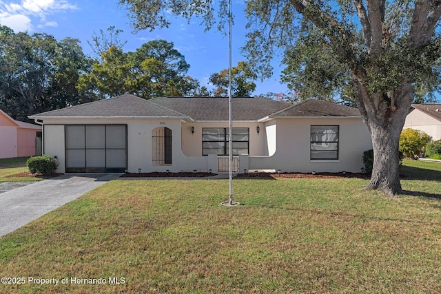 ranch-style home with a garage and a front lawn