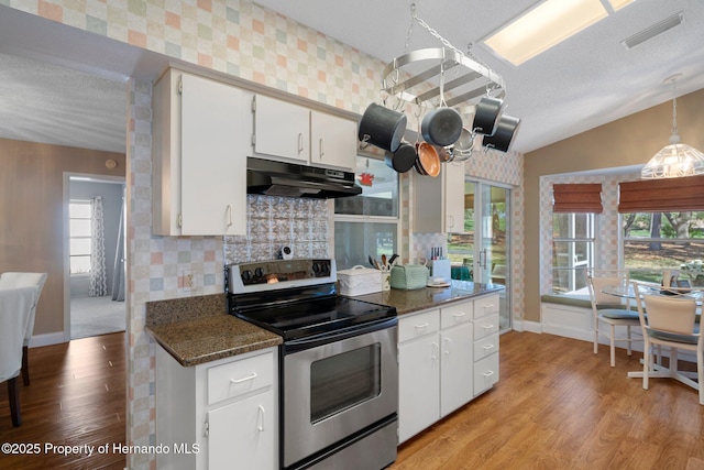 kitchen featuring under cabinet range hood, visible vents, white cabinets, stainless steel electric stove, and dark stone counters