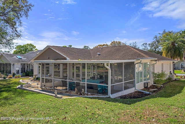 rear view of property featuring a sunroom and a yard