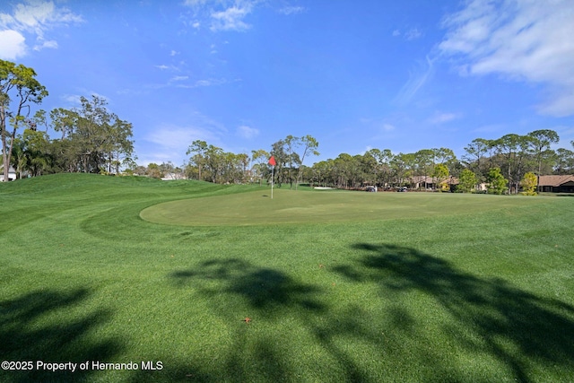 view of home's community featuring golf course view and a lawn