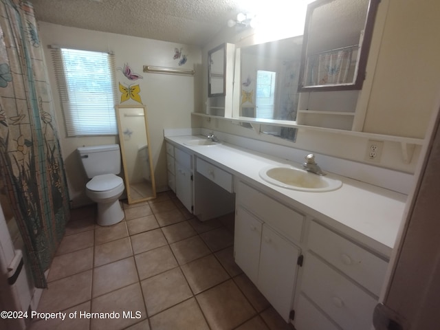 bathroom featuring vanity, tile patterned floors, a textured ceiling, and toilet