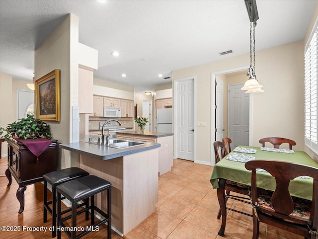 kitchen with sink, hanging light fixtures, light tile patterned floors, kitchen peninsula, and white appliances