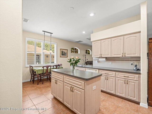 kitchen featuring pendant lighting, a center island, tasteful backsplash, and light tile patterned floors