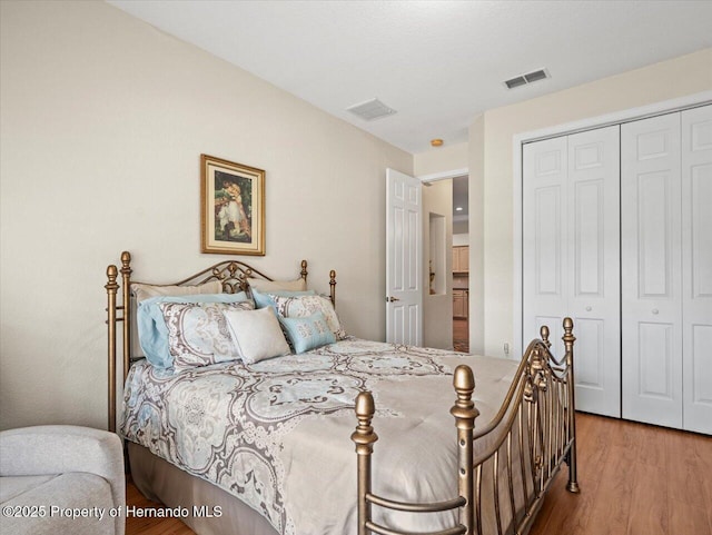 bedroom with light hardwood / wood-style floors and a closet