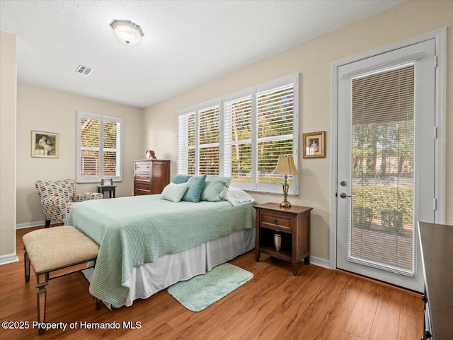 bedroom featuring hardwood / wood-style flooring and access to exterior