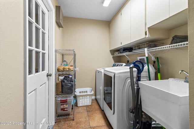 laundry room with sink, cabinets, a textured ceiling, and washer and clothes dryer