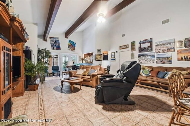 living room with beamed ceiling and a towering ceiling