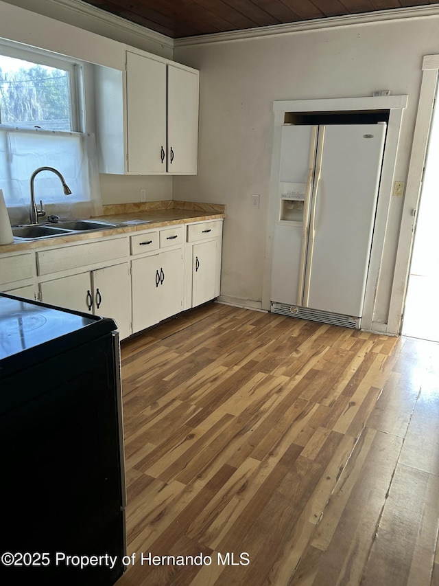 kitchen with white cabinetry, electric range, sink, and white fridge with ice dispenser