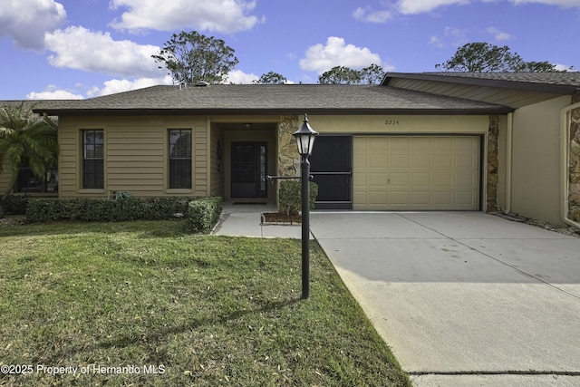 ranch-style house featuring a garage, roof with shingles, driveway, and a front lawn