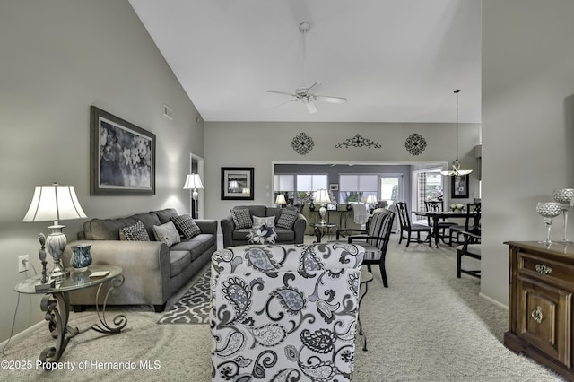 living area with light colored carpet, visible vents, baseboards, high vaulted ceiling, and ceiling fan