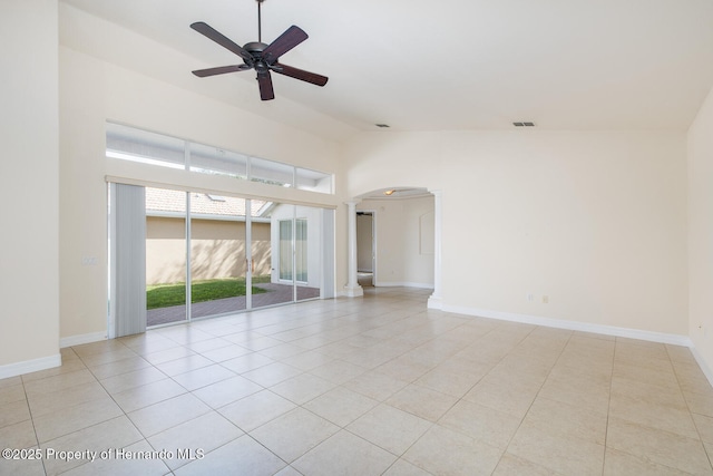 empty room with ceiling fan, a high ceiling, and light tile patterned floors