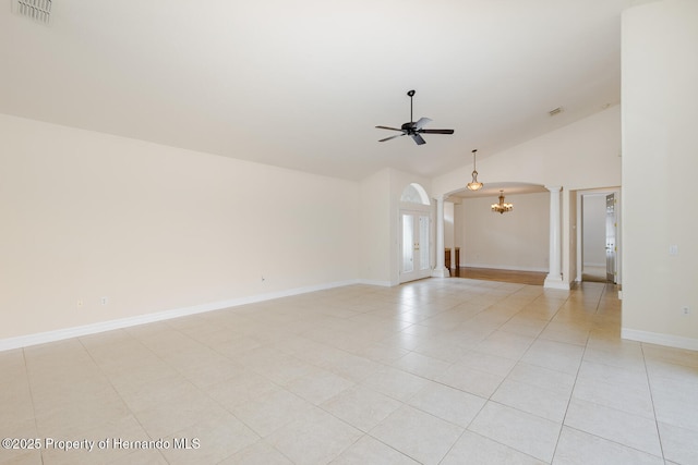 unfurnished room featuring high vaulted ceiling, ceiling fan with notable chandelier, decorative columns, and light tile patterned floors