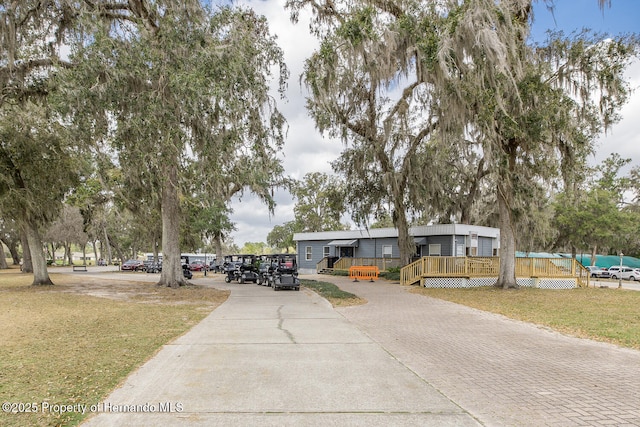 manufactured / mobile home featuring a wooden deck and a front yard