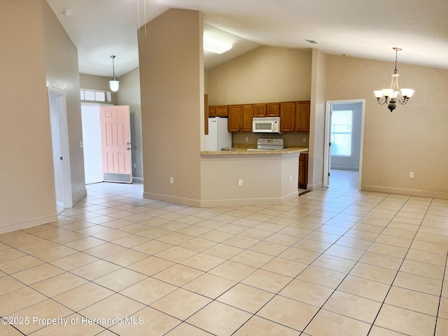 kitchen featuring light countertops, white appliances, light tile patterned flooring, and brown cabinets