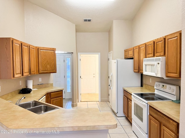 kitchen with light countertops, white appliances, and a sink