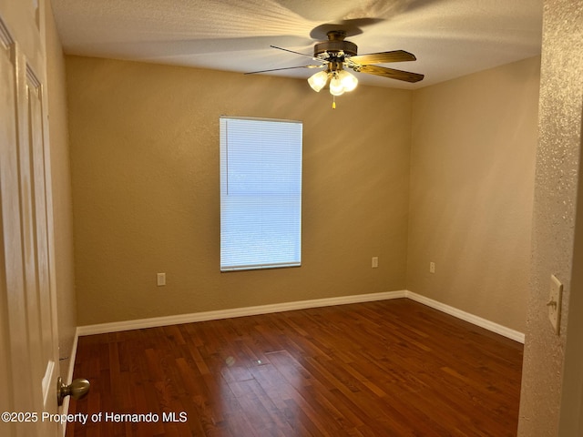 spare room featuring a textured ceiling, wood finished floors, a ceiling fan, and baseboards