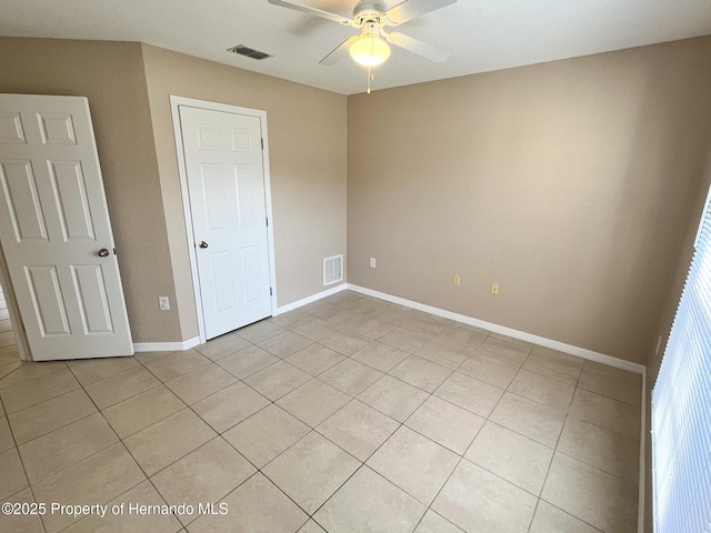 unfurnished bedroom featuring light tile patterned floors, baseboards, visible vents, and ceiling fan