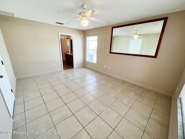 unfurnished bedroom with ceiling fan, light tile patterned flooring, visible vents, and baseboards