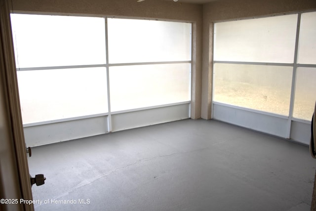 unfurnished sunroom featuring a ceiling fan