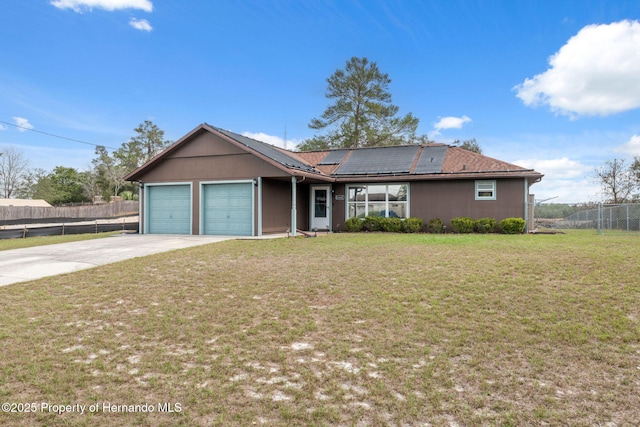 ranch-style home featuring a front yard, roof mounted solar panels, fence, and driveway