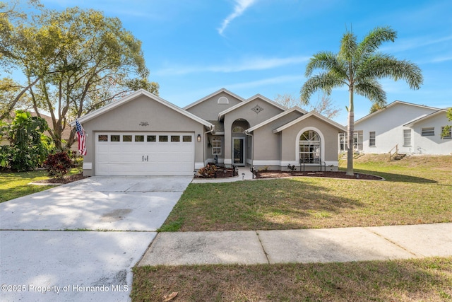 view of front facade featuring a front lawn, driveway, an attached garage, and stucco siding