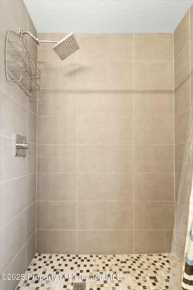 bathroom with a textured ceiling and walk in shower