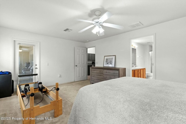 bedroom featuring ceiling fan, ensuite bath, and light colored carpet