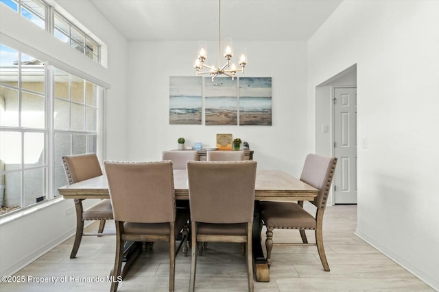 dining room with light hardwood / wood-style floors and an inviting chandelier