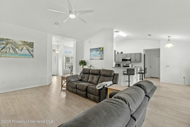 living room featuring light hardwood / wood-style flooring, ceiling fan, and vaulted ceiling