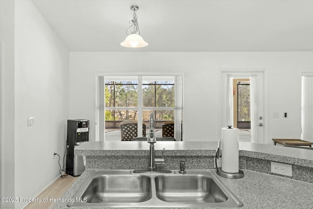 kitchen featuring light hardwood / wood-style floors, sink, and decorative light fixtures