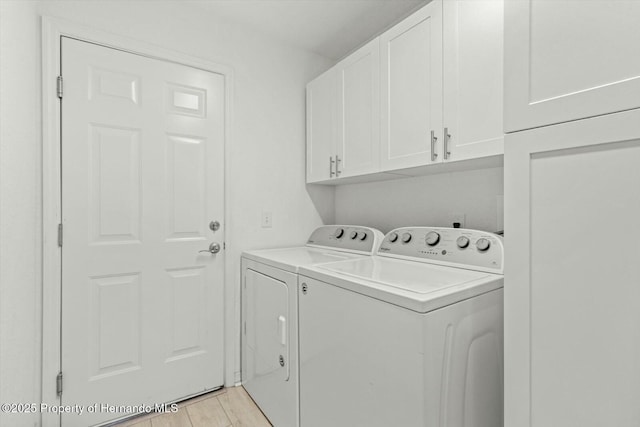 washroom with washer and clothes dryer, cabinets, and light wood-type flooring