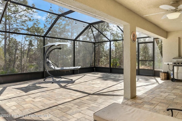 interior space featuring ceiling fan and glass enclosure